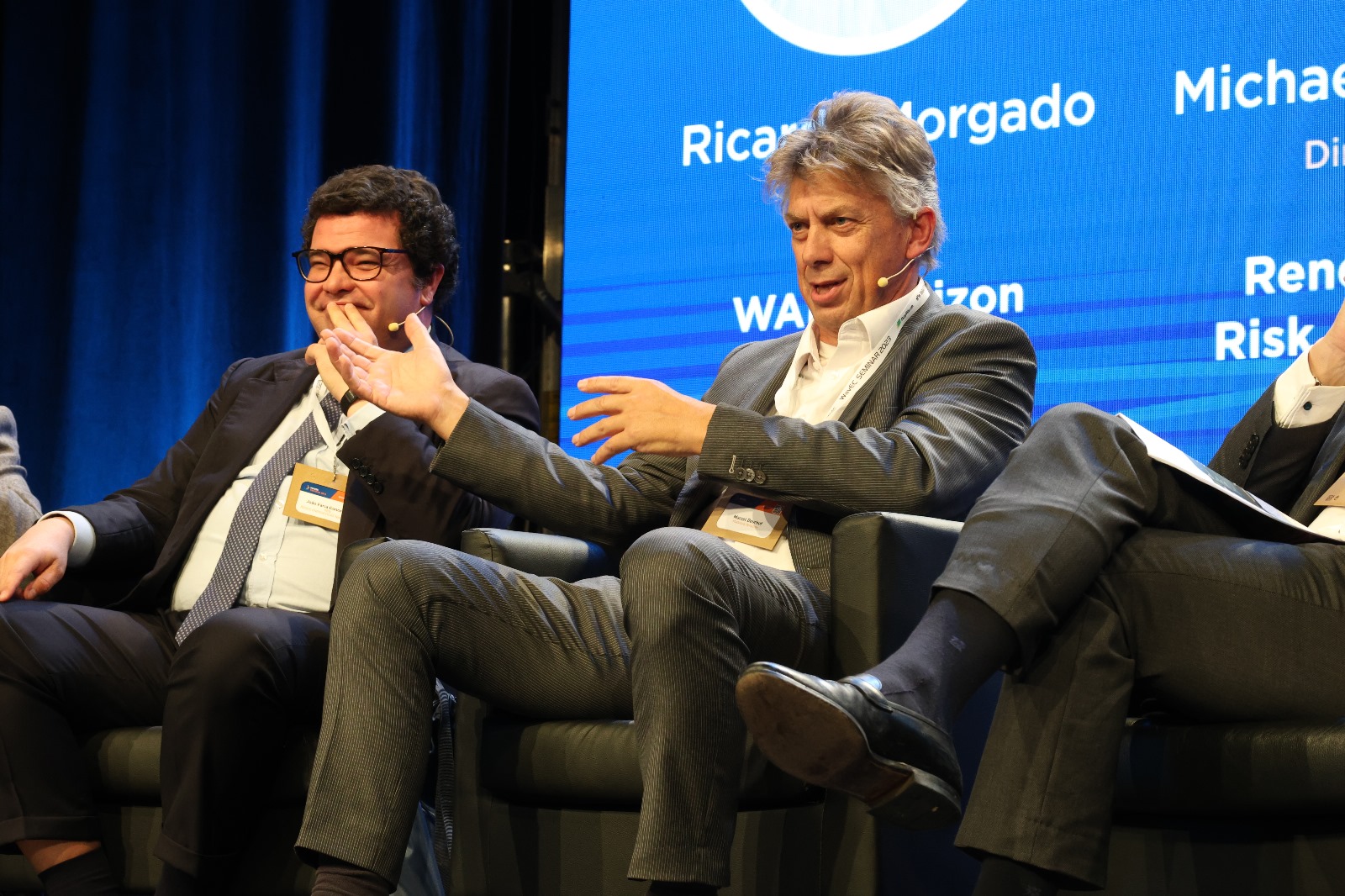 Marcel Deurhof speaking during a conference panel discussion, seated beside another panel speaker